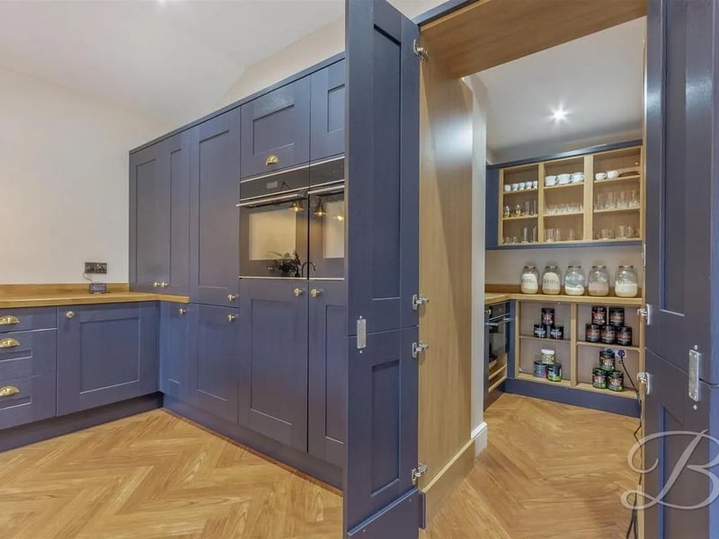 The stunning kitchen features a spacious hidden pantry