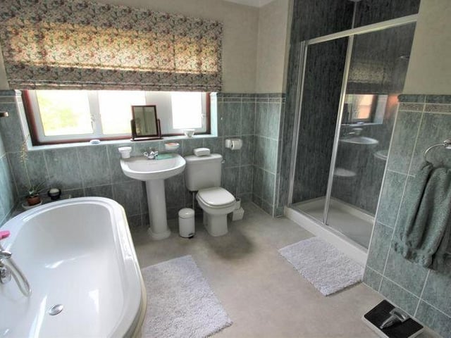 The large family bathroom on the first floor is fitted with a four-piece suite. It comprises a bath, low-flush WC, hand wash basin and shower cubicle with mains shower and glass screen. Fully tiled walls, vinyl flooring and an airing cupboard, housing a water tank, complete the room.