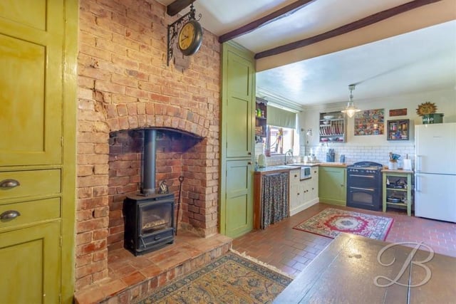 An outstanding feature of the kitchen is this log burner with brick surround. Note also the exposed beams that give the room plenty of character.