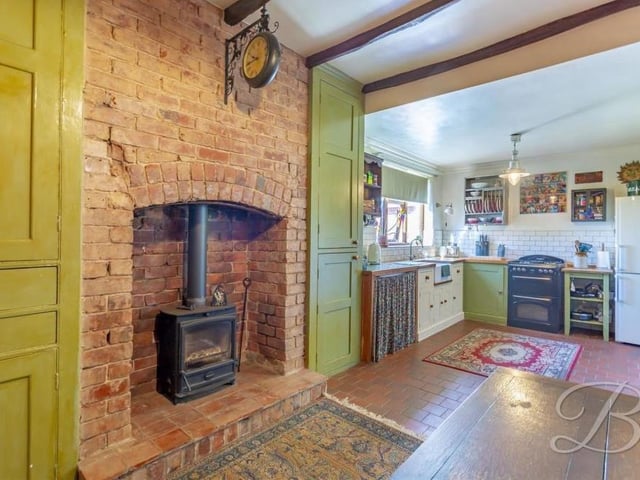 An outstanding feature of the kitchen is this log burner with brick surround. Note also the exposed beams that give the room plenty of character.