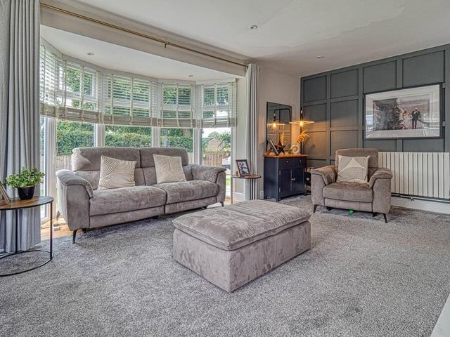 Here is the lovely, bright living room at the £600,000-plus property, with a floor-to-ceiling bay window that gives views over neighbouring fields.