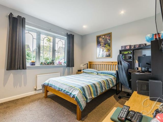 Beautifully designed windows, which you can see clearly in this double bedroom, are a feature of the entire property. Built-in wardrobes and a carpeted floor add to this room's appeal.