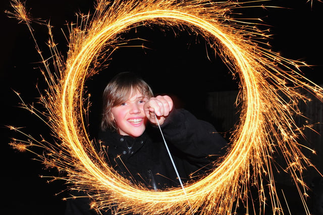A boy makes light circles with a sparkler during Bonfire Night celebrations. (Photo by Mike Hewitt/Getty Images)
