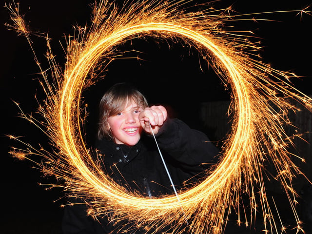 A boy makes light circles with a sparkler during Bonfire Night celebrations. (Photo by Mike Hewitt/Getty Images)