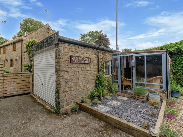 This quirky, detached garage is fitted with electrics and lighting.
