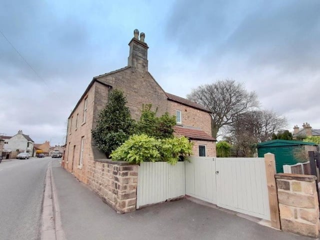 Time now to step outside, and here is a side view of the cottage, with gates leading to the driveway and back garden.