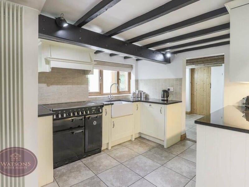 Work surfaces in the dining kitchen at The Three Horseshoes incorporate an inset Belfast sink. Other features include a boiler and a tiled floor.