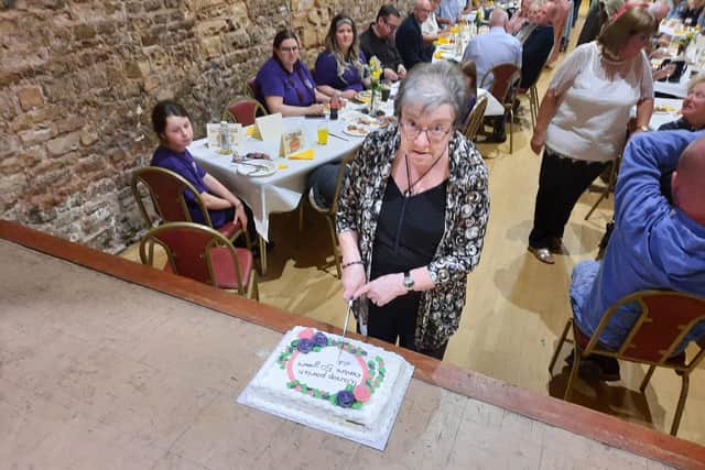 Pictured - Janice Crookes cutting the celebratory cake.