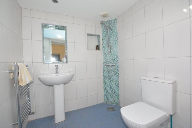 This is one of the en suite shower rooms. It consists of a walk-in shower, low-level WC, wash hand basin and heated towel-rail.