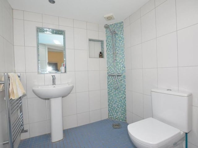 This is one of the en suite shower rooms. It consists of a walk-in shower, low-level WC, wash hand basin and heated towel-rail.