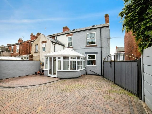 As we step outside, this is what the house looks like from the rear, with the conservatory jutting out. The block-paved space can be accessed via gates from a shared driveway to the side.