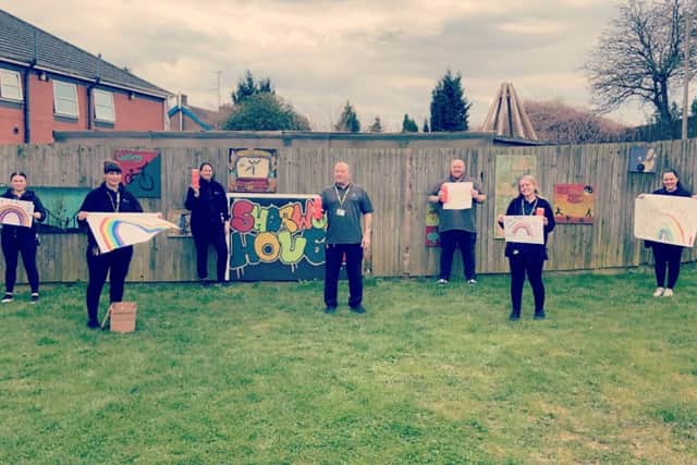 The team at Sherwood House showing off artwork by patients and staff to support the Rainbow Trail campaign.