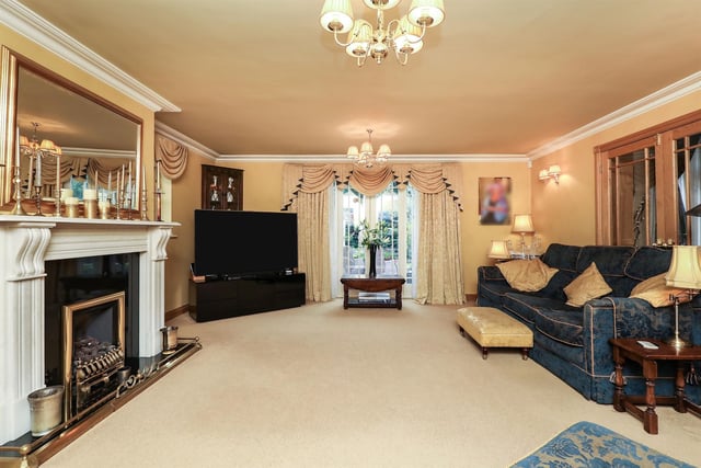 The sitting room has a decorative marble fireplace with a gas fire set on a granite hearth. French doors open onto the rear garden.
