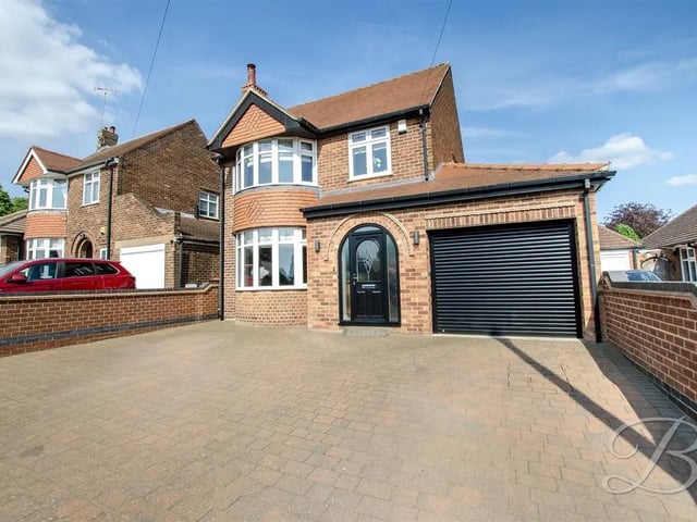 Enjoying a private frontage, the property features a spacious paved driveway and an attached garage, providing secure off-road parking for multiple vehicles.