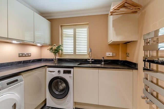 Even the utility room at The Dell benefits from high-quality fixtures and fittings, thanks to modern, gloss cream cabinets, an inset stainless steel Franke sink unit, a tiled floor and ceiling spotlights. There is plumbing for a washing machine and space for a tumble dryer..