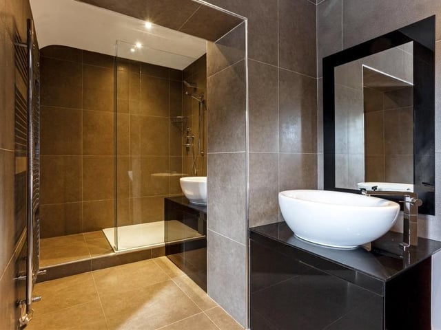 The second bathroom at the Mansfield property comprises a shower cubicle, corner bath, WC and hand wash basin in a vanity unit.