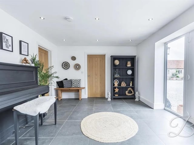 The entrance hall features stylish tiled flooring adding both elegance and practicality. Natural light fills the space through windows to the side elevation, creating a bright and airy first impression. From here, doors lead to the main living areas of the home, providing seamless access throughout.