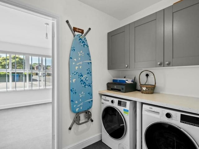 This utility room is a handy addition to the ground floor. It features cupboards, a worktop and space and plumbing for a washing machine and tumble dryer.