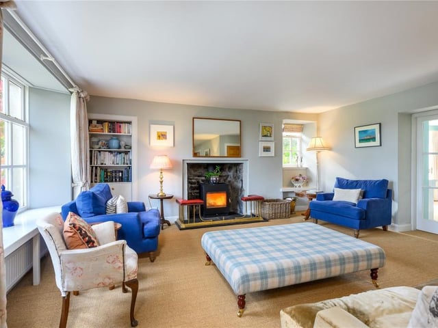 The living room includes a fireplace with wood burner.