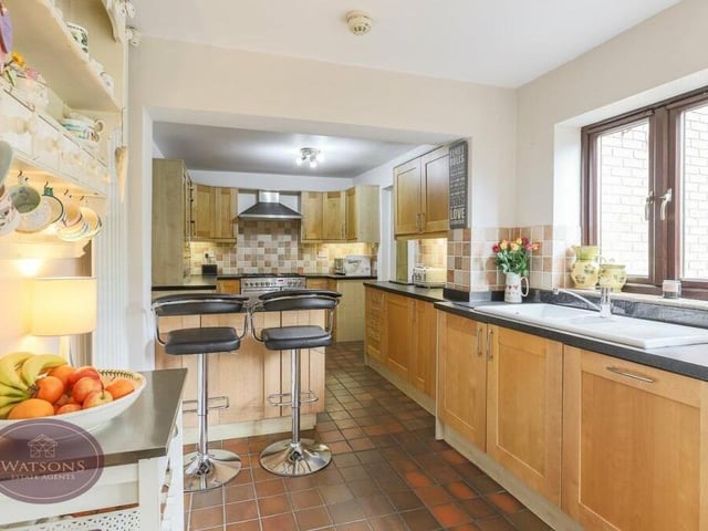 Moving on to the spacious, open-plan kitchen/;diner, which overlooks the back garden. It features a range of matching, solid-wood wall and base units and granite work surfaces incorporating an inset one-and-a-half-bowl sink and drainer unit.