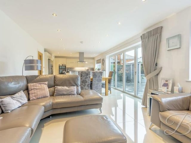 The open-plan living area at the Derby Road house from a different angle. The floor is tiled, while large bi-folding doors lead out to the back garden.