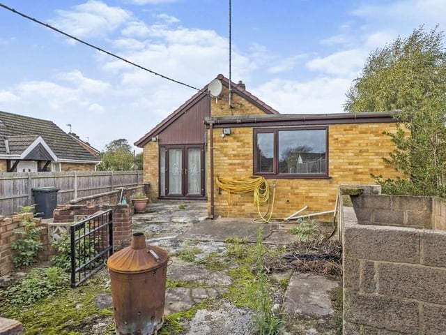 This is how the bungalow looks from the rear, where there is a raised patio area and access to a shed, fitted with power.