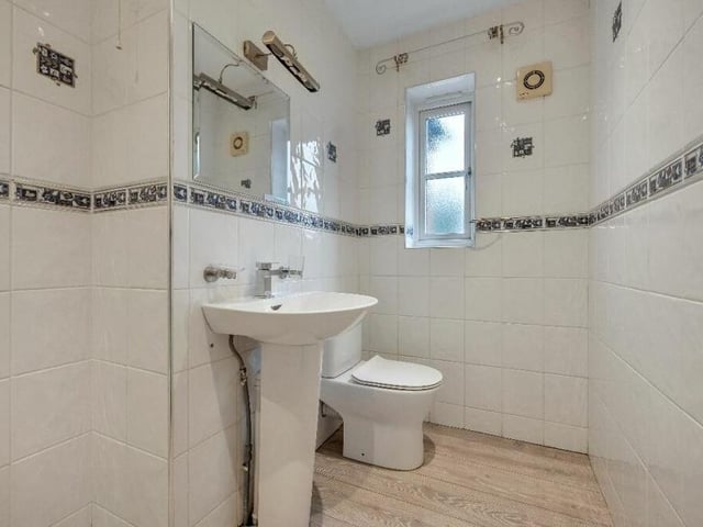 Two of the bedrooms are served by en suite shower rooms. Here is the second one, which includes a wash hand basin with chrome mixer tap, and a low-flush WC.