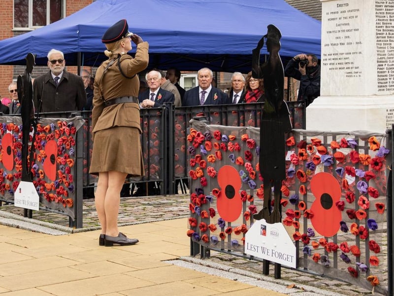 A member of the armed services salutes the Eastwood war memorial after laying a wreath.