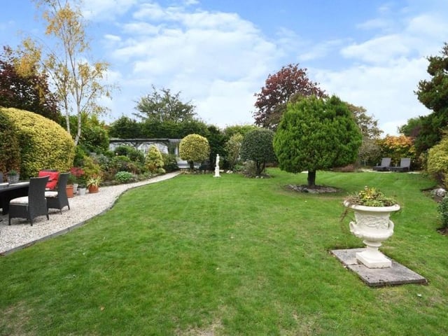 Another shot of the extensive grounds at the back of the property, complete with seating areas.