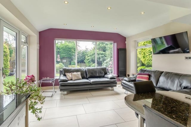 The living space within the open-plan dining kitchen is bright and modern, with a tiled floor, underfloor heating, a vertical radiator, ceiling spotlights and French doors leading out to the rear garden.