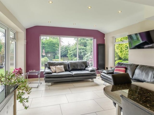 The living space within the open-plan dining kitchen is bright and modern, with a tiled floor, underfloor heating, a vertical radiator, ceiling spotlights and French doors leading out to the rear garden.
