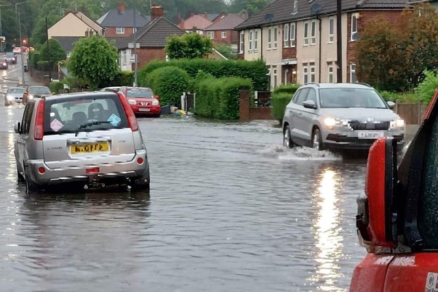 A car pictured driving through the water in the Spring Bank area of Sutton.