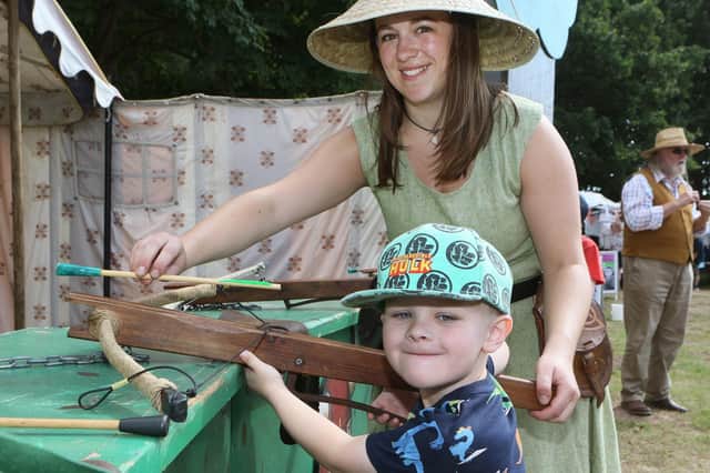 Rose Hemingway shows Lewis Pearson how to shoot the crossbow.