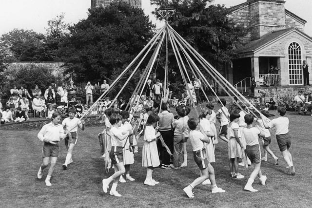 Greatham youngsters preform the Maypole dance with church and chapel in the background in July 1983.
