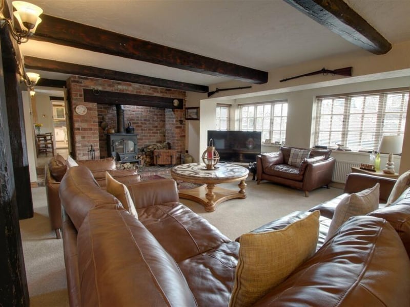 The eyecatching focal point of the lounge is a superb fireplace with a wood-burning stove.