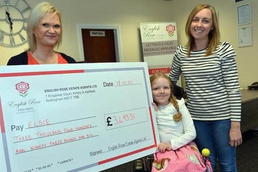 English Rose estate agents at Kirkby presented a cheque to Elsie Novell who needs a new wheelchair. Seen here are English Rose company director Julie Cotterill presenting the cheque to Elsie Novell and her mum Charlotte Novell.