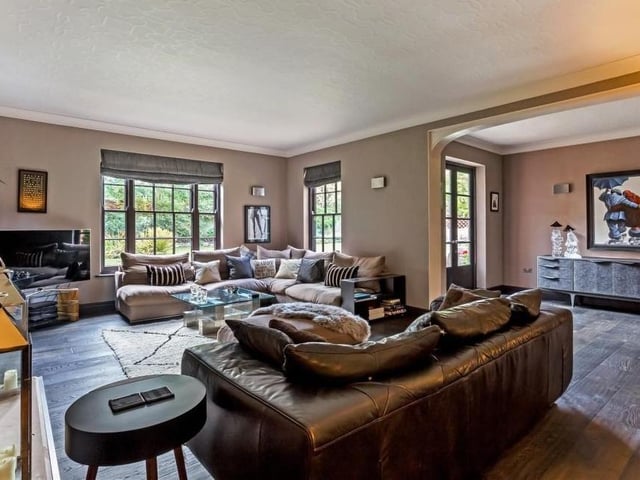 The main sitting room is a substantial space with engineered oak flooring and sash windows facing the back of the house. French doors open out to the patio area in the back garden.