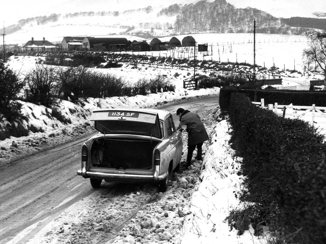 A motorist broken down in the snow at Hillend in 1963.