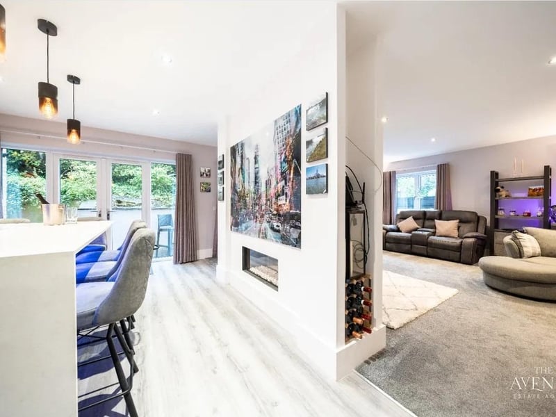 An impressive large living room is currently separated by a partial wall featuring a stunning fire place, dividing this space beautifully into two entertaining areas. On the other side of the wall, is a stunningly appointed reception area featuring a bar area.