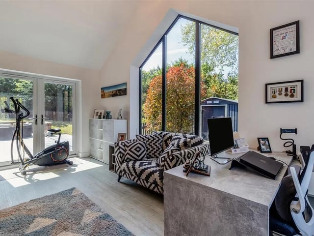 Bi-fold doors either side of the fireplace open to a bright and airy, triple aspect, snug which features a 4m high vaulted ceiling.