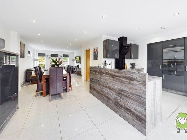 We open our gallery with the first of several looks at the high-quality, open-plan kitchen/dining area/living room. The kitchen has sleek, grey units and worktops and a full range of integrated appliances. As you can see, there is also plenty of room for a dining table.