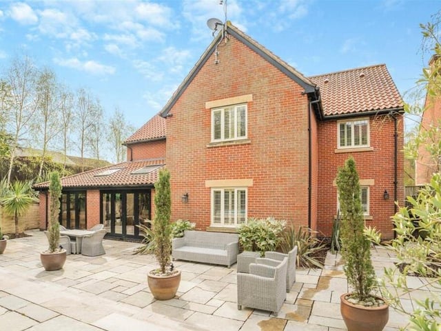 As we ,move outside now, here is a view of the rear of  the £1.2 million property. It shows how the French doors from the open-plan kitchen/diner lead on to a stone paved area, with seating space, that stretches the width of the house.