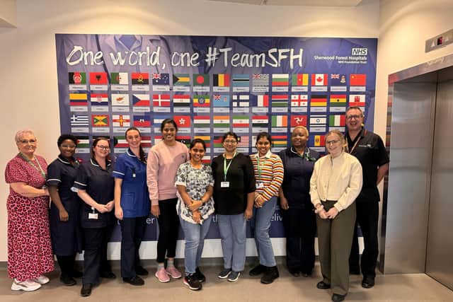 Sherwood Forest Hospital's overseas colleagues in front of the flag artwork at King’s Mill Hospital.