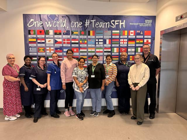Sherwood Forest Hospital's overseas colleagues in front of the flag artwork at King’s Mill Hospital.