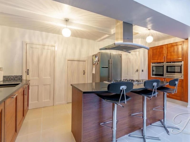 At the heart of the kitchen is a central island, where the family could take breakfast. A worktop includes an inset sink and drainer with mixer tap.