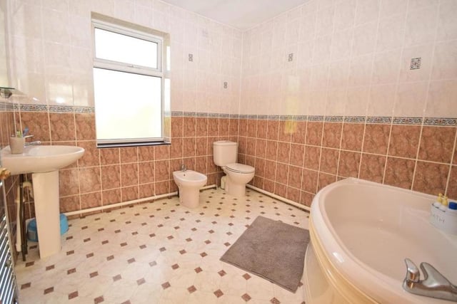The two bedrooms at the back end of the first floor both have their own en suite facilities. This room comprises a panelled spa corner bath, low-flush WC, wash basin, bidet and chrome heated towel-rail. The floor is tiled.