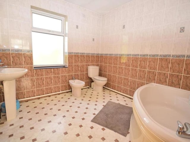 The two bedrooms at the back end of the first floor both have their own en suite facilities. This room comprises a panelled spa corner bath, low-flush WC, wash basin, bidet and chrome heated towel-rail. The floor is tiled.