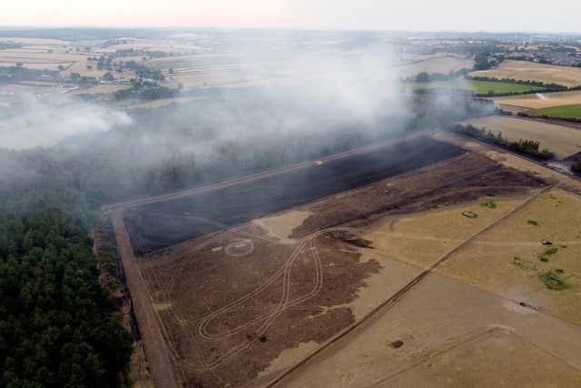 Burnt woodland is seen in Blidworth while smoke rises from the trees following the fire on July 19.