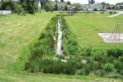 An overhead shot of a typical bioswale by a playing field.