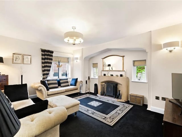 The lounge features double glazed windows to the front and side aspects, door leading to the hallway, feature fireplace with stone hearth and mantle with log burner within, carpeted flooring and a radiator.